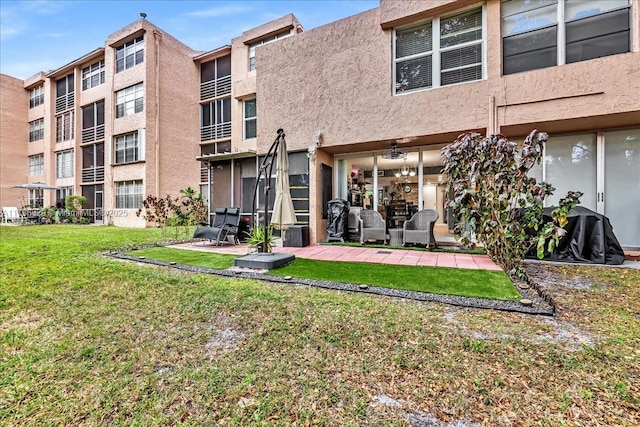 rear view of property with a yard and a patio area