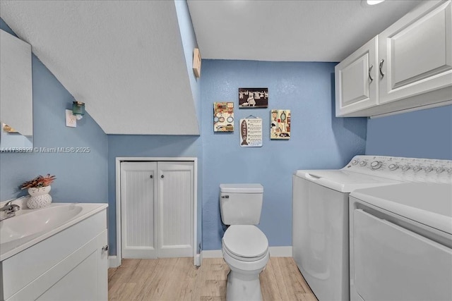 washroom featuring separate washer and dryer, sink, and light hardwood / wood-style floors