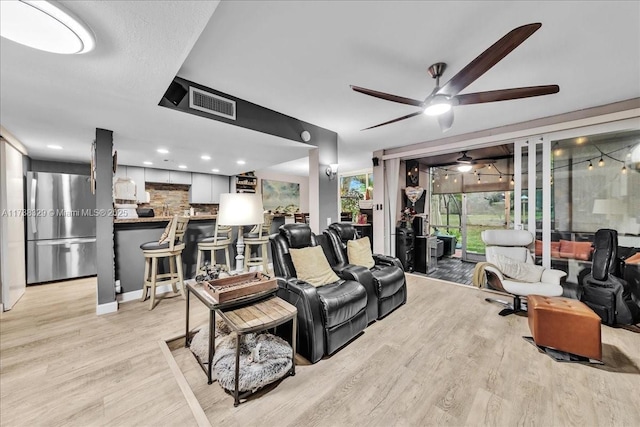 living room featuring ceiling fan and light wood-type flooring