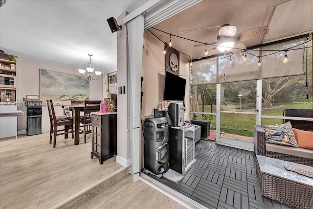 sunroom / solarium featuring a chandelier