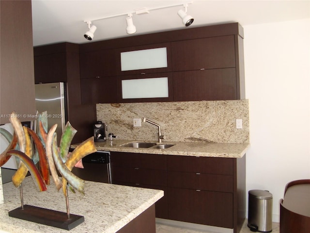 kitchen featuring stainless steel appliances, sink, light stone counters, and decorative backsplash