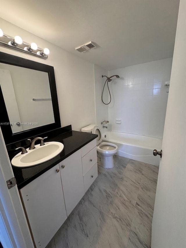 full bathroom with vanity, tiled shower / bath, and toilet