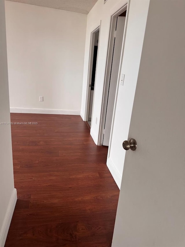 hallway with dark wood-type flooring