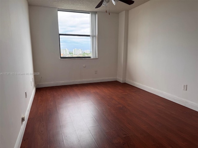 unfurnished room featuring ceiling fan, a textured ceiling, and dark hardwood / wood-style flooring