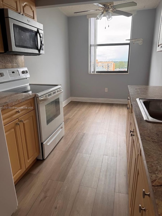 kitchen with sink, light hardwood / wood-style flooring, ceiling fan, white electric stove, and light brown cabinets