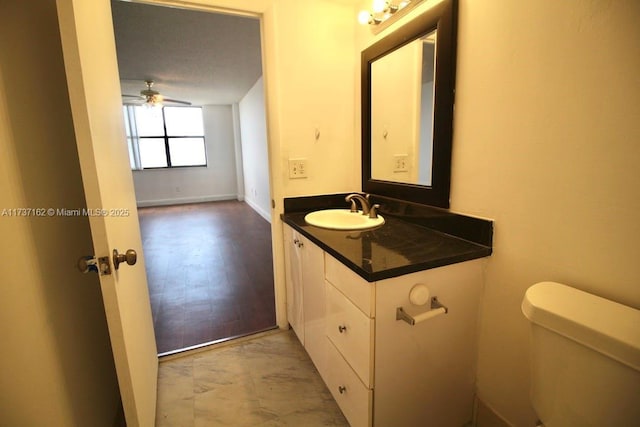 bathroom featuring ceiling fan, vanity, and toilet