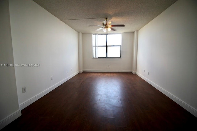 unfurnished room featuring ceiling fan, dark wood-type flooring, and a textured ceiling