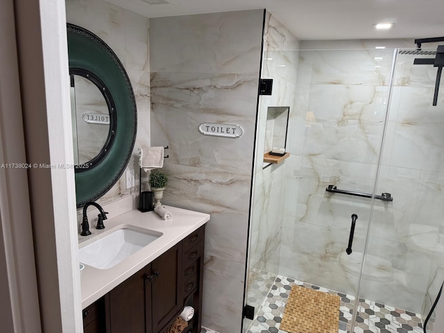 bathroom featuring vanity and a shower with shower door