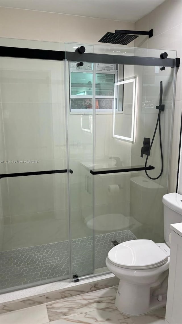 bathroom with an enclosed shower, vanity, and toilet