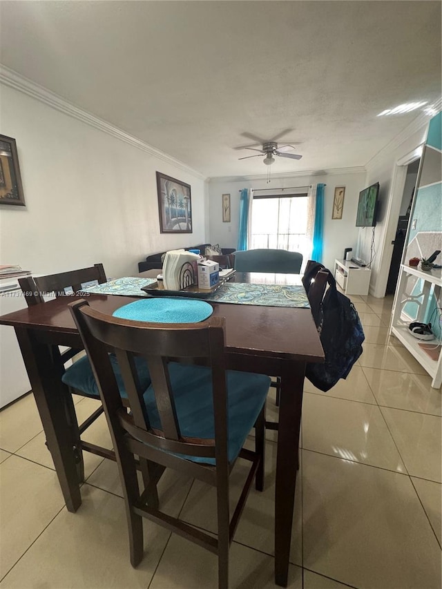 tiled dining room featuring crown molding and ceiling fan