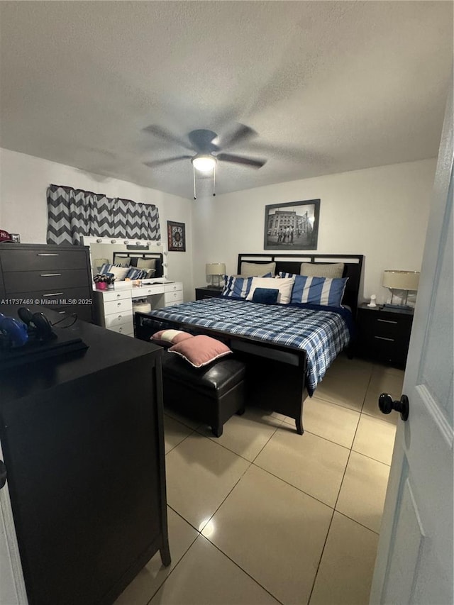 tiled bedroom featuring ceiling fan and a textured ceiling