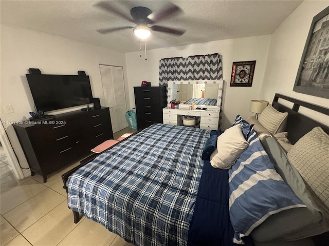 tiled bedroom featuring ceiling fan, a closet, and a textured ceiling