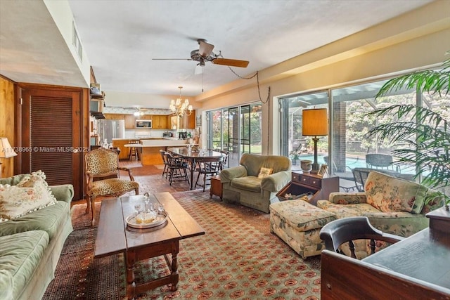 living room with ceiling fan with notable chandelier