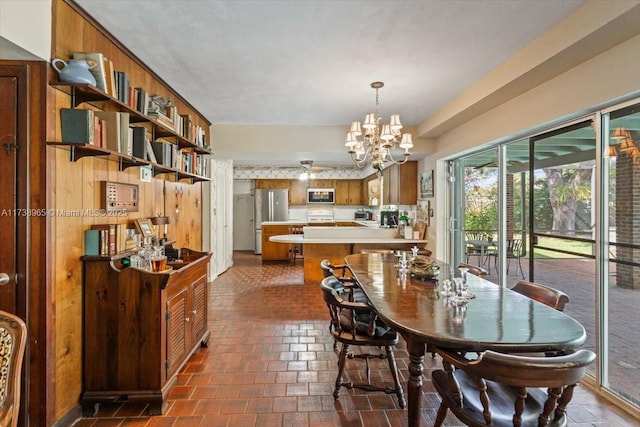 dining room featuring wood walls and a notable chandelier