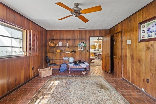 interior space with wooden walls and ceiling fan