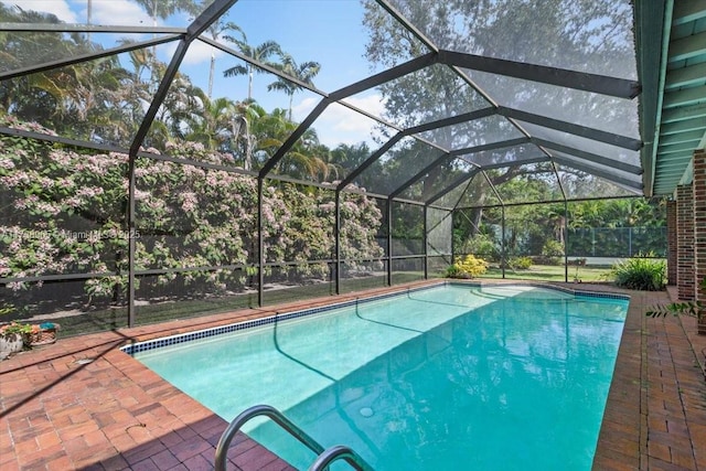 view of pool featuring glass enclosure and a patio area