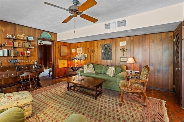 living room featuring wooden walls and ceiling fan