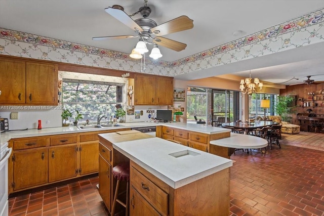 kitchen featuring hanging light fixtures, a kitchen island, sink, and plenty of natural light