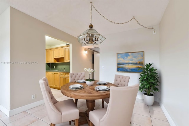 dining area with baseboards, an inviting chandelier, and light tile patterned floors