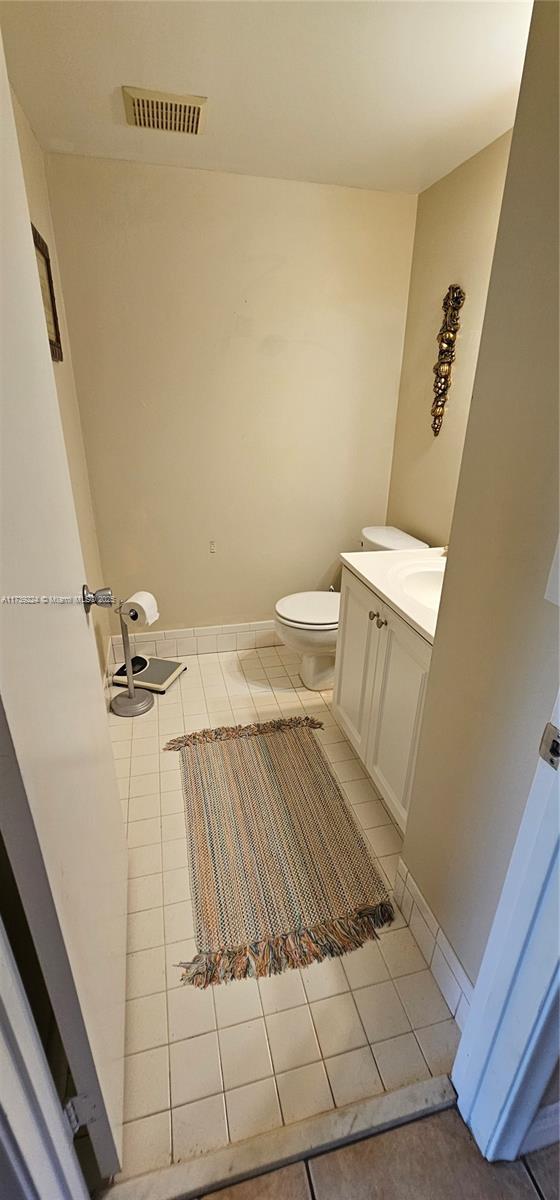 bathroom featuring tile patterned flooring, vanity, and toilet