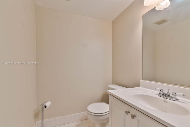 bathroom featuring tile patterned flooring, toilet, vanity, visible vents, and baseboards