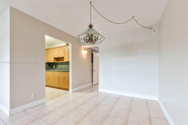 unfurnished dining area featuring light tile patterned floors, baseboards, a textured ceiling, and an inviting chandelier