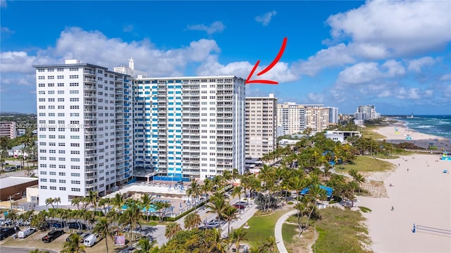 view of building exterior with a water view and a beach view