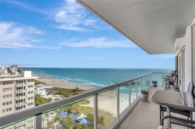 balcony featuring a water view and a beach view