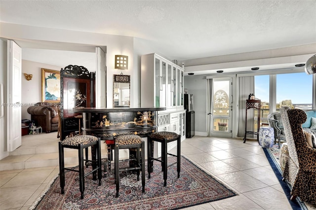 dining space featuring a textured ceiling and light tile patterned floors