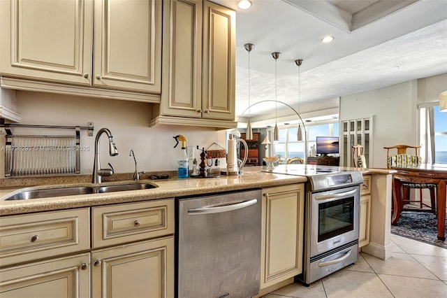 kitchen featuring sink, light tile patterned floors, cream cabinetry, and appliances with stainless steel finishes