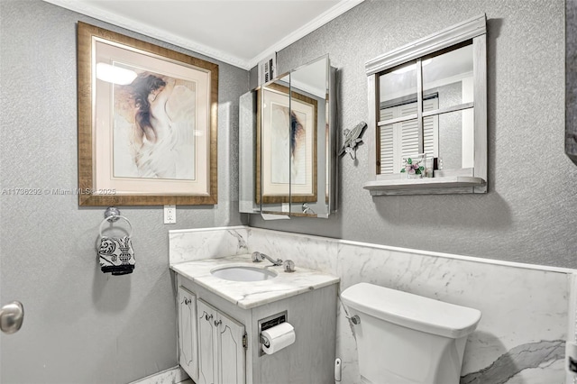 bathroom featuring vanity, ornamental molding, and toilet