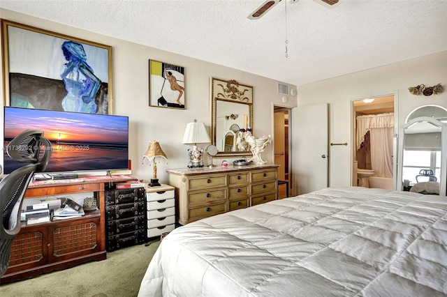 carpeted bedroom featuring ceiling fan, a textured ceiling, and ensuite bath