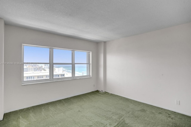 spare room with a water view, carpet floors, and a textured ceiling