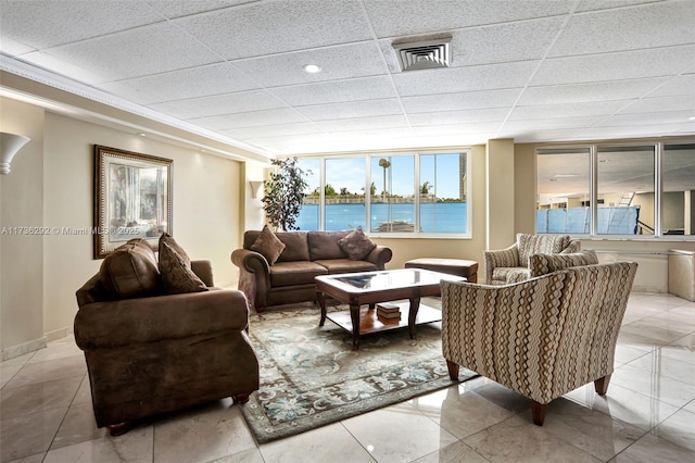 living room featuring a drop ceiling and a water view