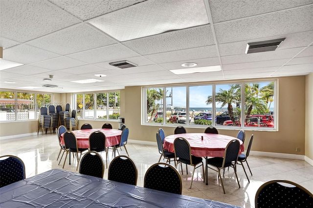 tiled dining room with a drop ceiling