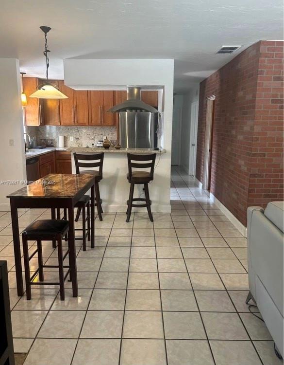 kitchen with decorative light fixtures, exhaust hood, dishwasher, and light tile patterned flooring