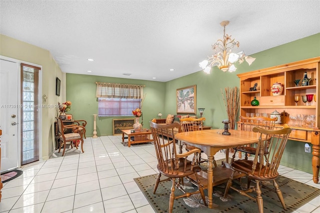 tiled dining space with an inviting chandelier and a textured ceiling