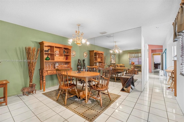 tiled dining area featuring an inviting chandelier and a textured ceiling