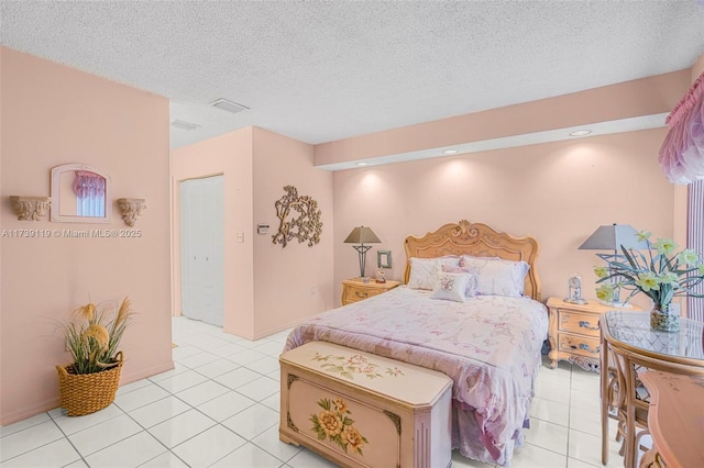 bedroom featuring light tile patterned flooring and a textured ceiling