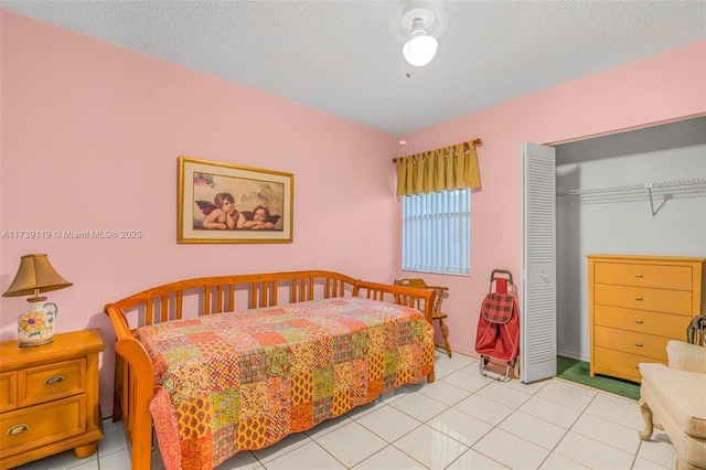 bedroom with light tile patterned floors, a closet, and a textured ceiling