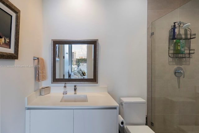 bathroom featuring vanity, toilet, and a tile shower