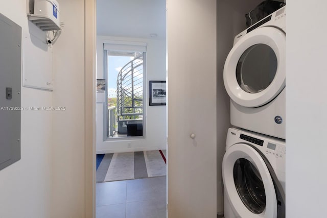 laundry room with tile patterned floors and stacked washer and clothes dryer