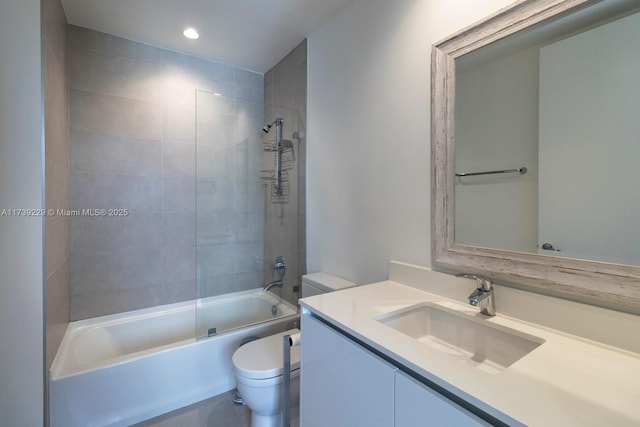 full bathroom with tiled shower / bath, vanity, and toilet