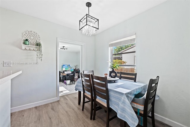 dining room with light hardwood / wood-style floors and a notable chandelier