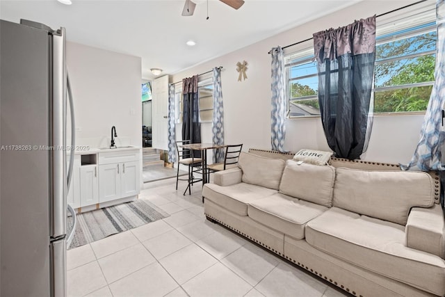 living room featuring sink, light tile patterned floors, and ceiling fan