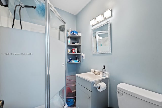 bathroom featuring an enclosed shower, vanity, and toilet