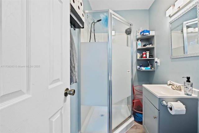 bathroom with vanity, a shower with shower door, and wood-type flooring