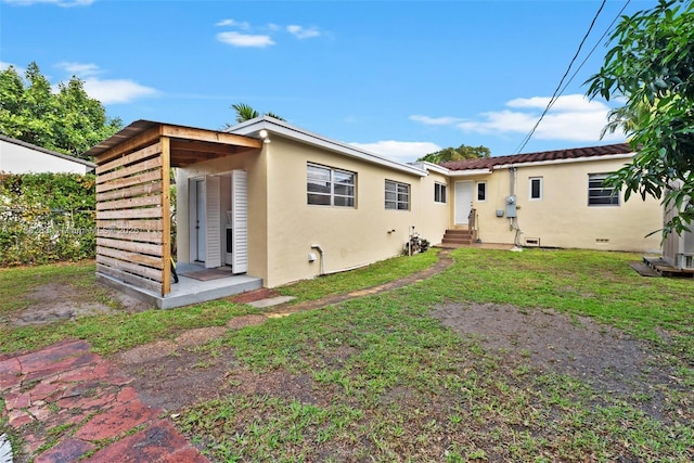 rear view of house featuring a lawn