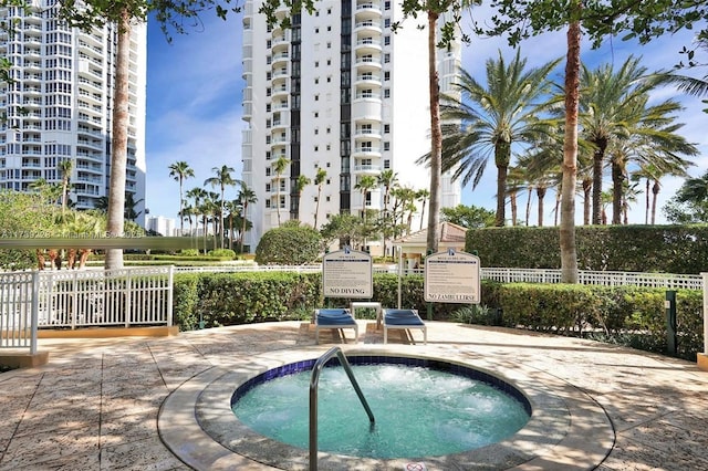 view of swimming pool featuring a hot tub and a patio