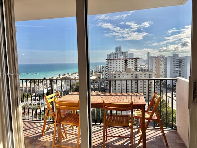 balcony with a water view and a beach view